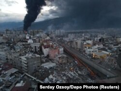 Черный дым от пожаров поднимается над уничтоженным землетрясением центром турецкого города Искендерун. 7 февраля 2023 года