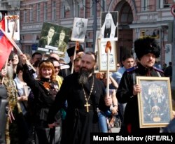 В акции "Бессмертный полк" участвовали священнослужители и люди, называющие себя "казаками" - один из них почему-то взял на шествие не фотографию родственника-фронтовика, а икону