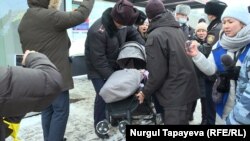 Полиция бес айлық сәбиімен жүрген әйелді коляскасымен ұстап барады. Нұр- Сұлтан, 4 қаңтар 2022 жыл.