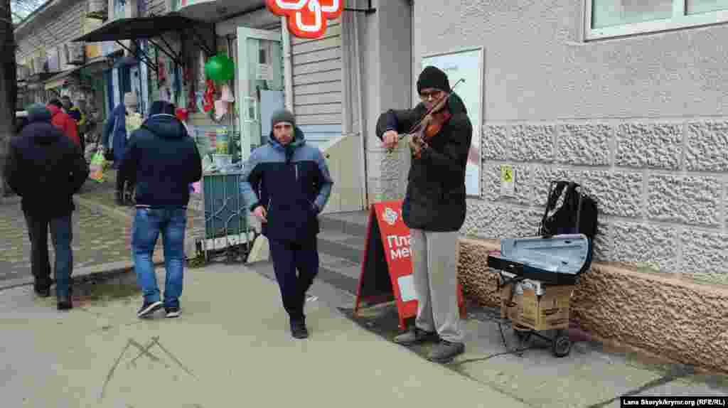 Вуличний скрипаль створює святковий настрій перехожим