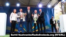 Посол жіночої Ліги чемпіонів, гравець національної жіночої збірної України Ія Андрущак, президент ФФУ Андрій Павелко, мер Києва Віталій Кличко, віце-президент УЄФА Григорій Суркіс, український футболіст, головний тренер збірної України з футболу Андрій Шевченко під час церемонії передачі Кубків Ліги чемпіонів УЄФА місту Києву