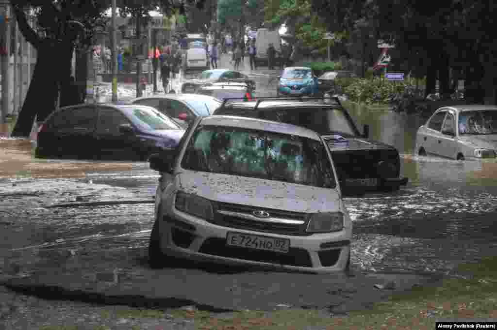 Автівки намагаються проїхати затопленою вулицею