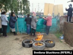 Алтын Червалиева мен оның туыстары сот шешімімен сүрілетін үйін қорғап тұр. Астана, 15 тамыз 2014 жыл.