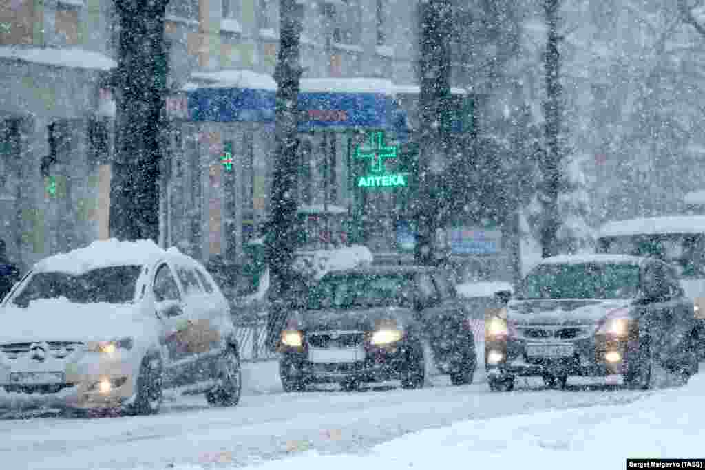 Автомобілі під час снігопаду на одній із вулиць Сімферополя