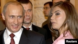 Prezident Vladimir Putin Kremldə Rusiya Olimpiya komandası ilə görüşdə Rusiya gimnastı Alina Kabayevanın yanında gülümsəyir. 2004-cü il