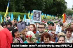 Чоловік із портретом головного командира УПА Романа Шухевича вирішив також пройтися разом із учасниками акції «Безсмертний полк». На нього не звертали уваги, допоки він не почав вигукувати гасло «Слава Україні!». Київ, 9 травня 2018 року