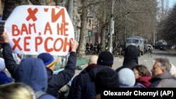 Люди стоять перед військовими Росії під час мітингу проти російської окупації. Херсон, 14 березня 2022 року