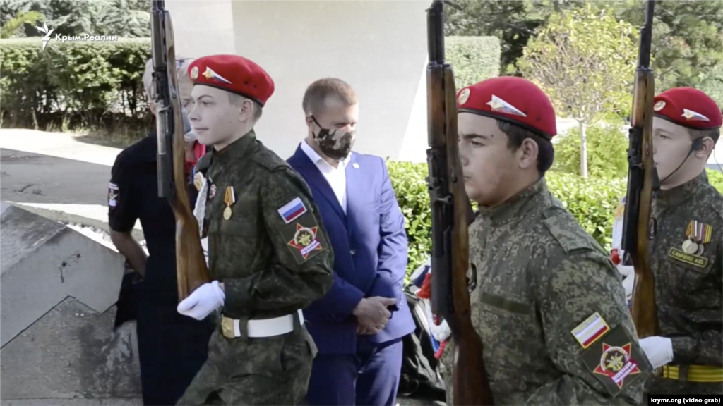 1 жовтня, Ялта. Кримські школярі беруть участь в акції &laquo;Вахта пам&#39;яті поколінь&raquo;. Вони одягнені в російську військову форму і тримають у руках зброю. Як повідомляв кореспондент Крим.Реалії, одна з учасниць втратила свідомість під час акції. Суть заходу полягала в тому, що діти урочисто заступали на &laquo;почесну варту&raquo; біля &laquo;Вічного вогню&raquo;. В акції брали участь учні кадетських класів, члени клубу ДОСААФ і руху &laquo;Юнармія&raquo;. Правозахисники розглядають сам факт існування таких класів і організацій, а також пропаганду війни та зброї серед дітей як мілітаризацію освіти в анексованому Криму. Вони називають це порушенням гуманітарного права і одним з елементів військового злочину Росії на півострові