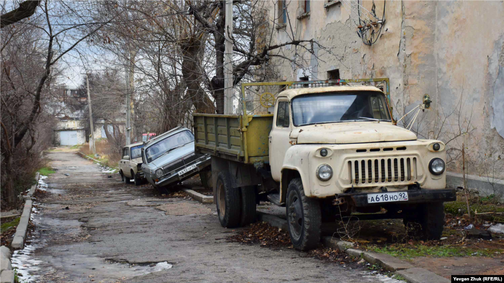 На вулиці кілька кинутих автомобілів, їх потихеньку розбирають на запчастини