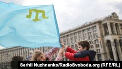 1944 жылы совет үкіметі Қырым татарларын атамекенінен Орталық Азия мен Сібірге күштеп жер аударған. Сталиндік саясат құрбандарын еске алу күні Қырым татарларының туын ұстап тұрған балалар. Киев, Украина, 18 мамыр (Сергей Нужненко).