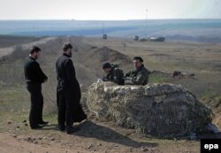 Священник розмовляє з українськими солдатами на блокпосту біля кордону з Росією в Донецькій області, 25 квітня 2014 року