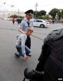 Російський поліцейський затримує хлопчика під час акції протесту в російському Петербурзі, 9 вересня 2018 року