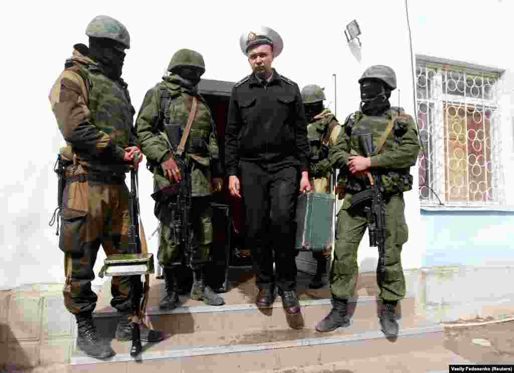 19 березня 2014 року, Севастополь. Український моряк в оточенні військових без розпізнавальних знаків