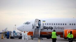 Група медиків поблизу літака авіакомпанії SkyUp, який прилетів з китайського міста Ухань, лютий 2020 року, «Бориспіль», Україна