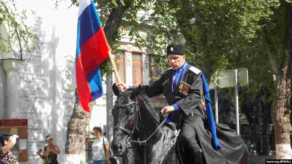 На чолі військово-музичної ходи їхали кілька людей у козацькій формі на конях