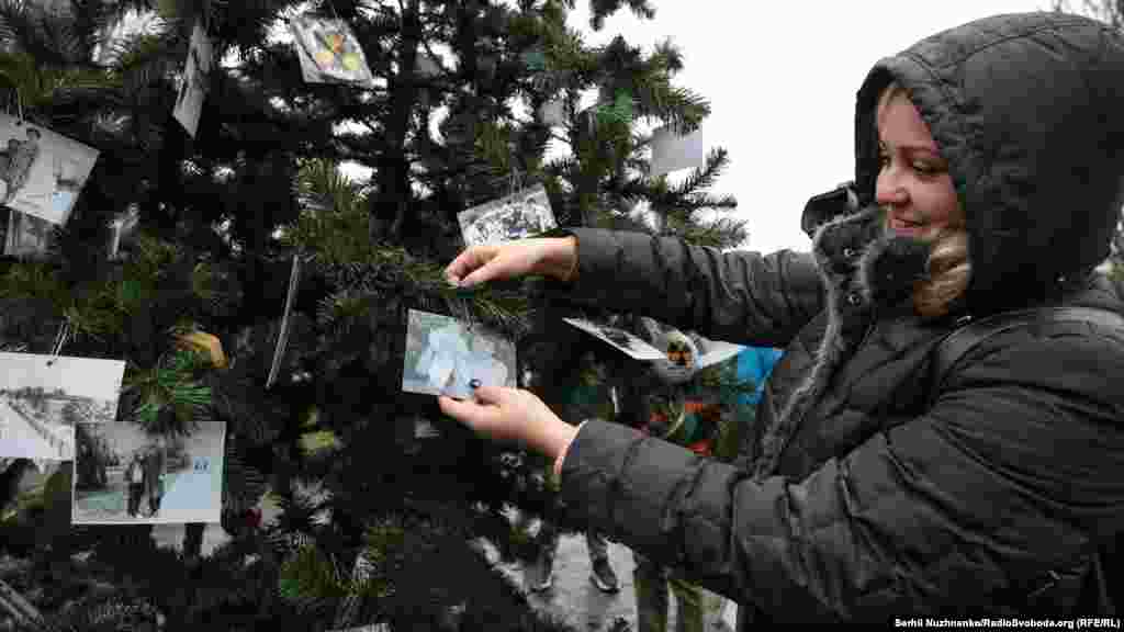 Дарина Дударенко прикріплює сімейне фото на встановленій новорічній ялинці. Вона народилася в Прип&#39;яті в січні 1986 року 