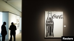 Coca-Cola сауда белгісі жанында тұрған адамдар. Көрнекі сурет.