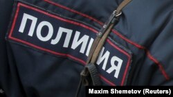 Russia - A woman looks at Russian police officers as they talk during a festive concert marking the second anniversary of Russia's annexation of the Crimea region, in Red Square in central Moscow, Russia, March 18, 2016.